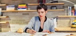 Image of woman writing in front of book shelf