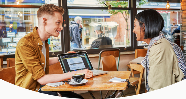 photo of two people sitting in a cafe working.
